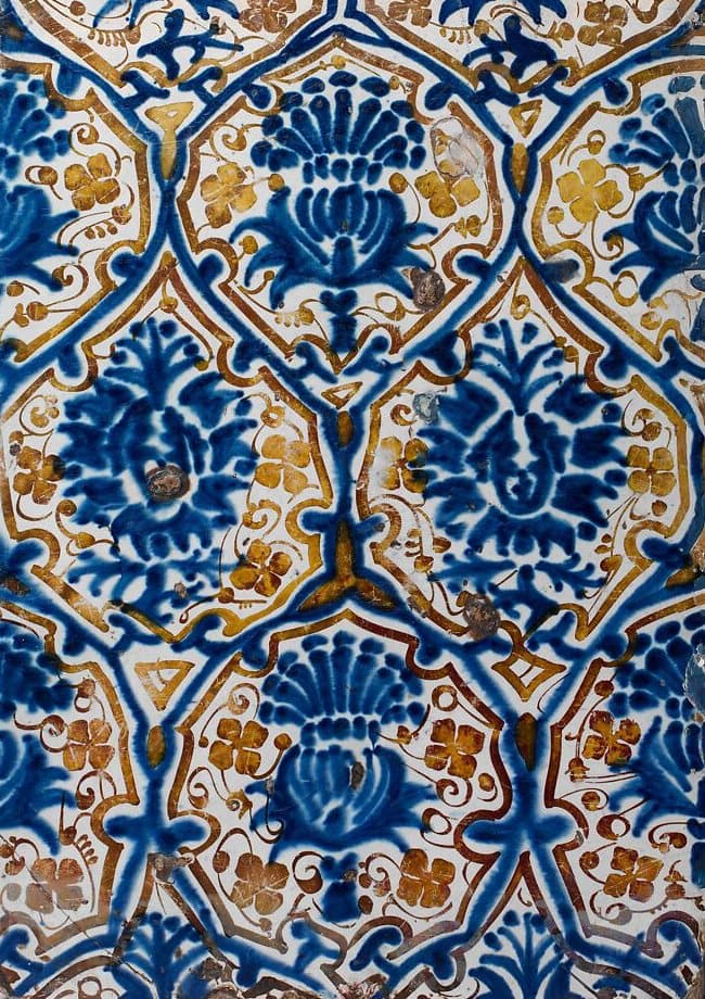 Azulejo de Manises del siglo XV con cardos y granadas en azul cobalto y reflejos dorados anaranjados